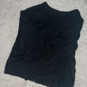 Svart stickad tröja med rund hals - Enkel svart stickad tröja med rund halsringning och långa ärmar. Perfekt basplagg att matcha med jeans eller kjol. Mjuk och skön känsla, passar dig som gillar stilrena och klassiska vibes.