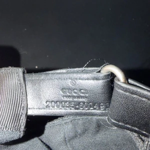 Gucci jumbo keps  - Snygg svart keps från Gucci med ikoniskt GG-mönster över hela kepsen. Justerbar rem bak i skinn och detaljer i svart textil. Perfekt för dig som vill ha en lyxig och stilren accessoar med streetkänsla.