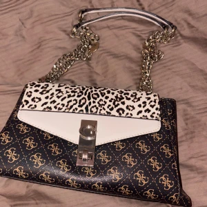 Guess axelväska🤎 - Snygg axelväska från Guess med kedjerem och detaljer i silver. 