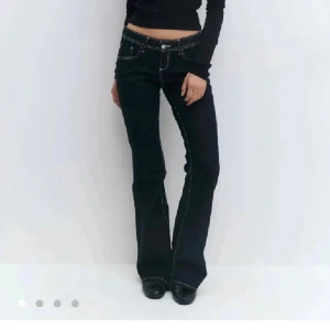 Ultra low flare jeans från Gina tricot, stl 40 - Mörkblå jeans med ultra låg midja och utsvängda ben från Gina tricot . Snygga kontrastsömmar och klassisk femficksmodell. Perfekta för dig som gillar 00-talsvibbar och vill ha en riktigt cool siluett.