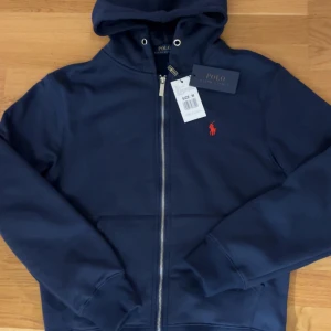 Marinblå hoodie från Polo Ralph Lauren - Snygg marinblå hoodie från Polo Ralph Lauren till dig som känner att du vill ha något lite snyggare och mer bekvämt nu när vintern kommer.‼️⚠️priset kan diskuteras 