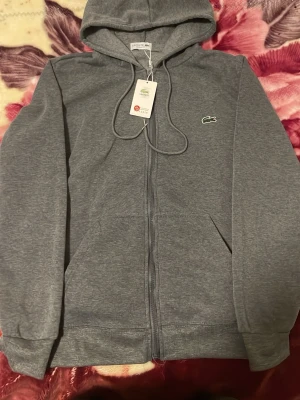 En hoodi Lacoste  - Jätte fin hoodi oanvänd grå färg 