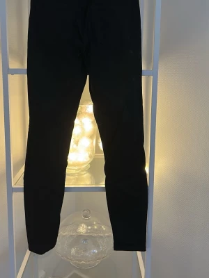 Svarta skinny jeans från vero Moda  - Svarta jeans från vero Moda med klassisk femficksdesign och skinny passform. Byxorna har knapp och dragkedja framtill samt smal siluett som sitter tajt längs benen. Perfekta för dig som gillar en stilren och enkel look.