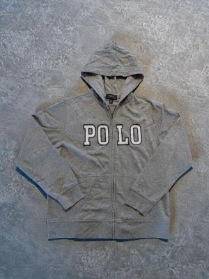 Grå Ralph Lauren zip hoodie - Fint skick, men lite nopprig! Passar ca 160 cm.  Axelbredd 42 cm  Längdmått 59 cm