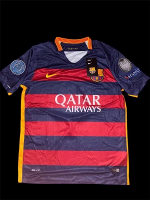 FC Barcelona Messi 10 matchtröja - Säljer en FC Barcelona matchtröja från Nike med Messi 10 på ryggen. Tröjan har breda marinblå och röda ränder, gula detaljer och klubbmärke på bröstet. Dri-Fit material, Champions League-patch på ärmarna och Qatar Airways tryck på framsidan.