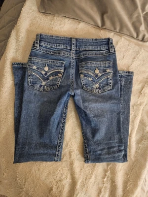 Snygga blå lågmidjade bootcut jeans med broderade fickor, Gina Tricot - Snygga low-waist bootcut blå jeans från Gina Tricot i storlek 152. Jeansen har klassisk femficksdesign och coola bakfickor med broderade mönster och paljetter. Använda max tre gånger, och därför i väldigt bra skick och priset. Jättesnygga, säljer då jag redan har massa andra jeans och dessa glöms bort i garderoben. Nypris 399 kr. 💓💓