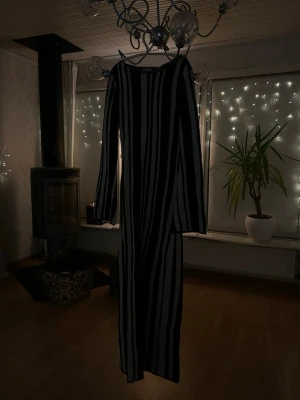 Randig långklänning från NA-KD - Säljer en svart och vit långklänning från NA-KD med vertikala ränder. Klänningen har långärmade ärmar och är stickad i ett mjukt material som känns skönt mot huden. Snygg och trendig design med rund halsringning och figurnära passform. Helt oanvänd!