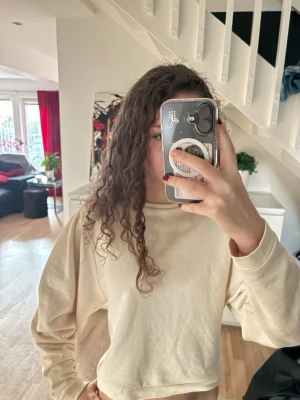 Beige croppad sweatshirt - Säljer en beige croppad sweatshirt med rund hals,  och långa, lite ” puffiga” ärmar. Tröjan har en loose passform och är ifrån Lindex i storlek Xs. Perfekt för en chill och avslappnad stil.