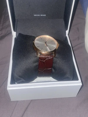 Calvin klein klocka swiss made - Bilderna visar en klocka från Calvin Klein med brun läderrem och guldfärgat Helt ny aldrig använd fick den i present så har inga papper ny pris 2500kr äkta brunt läder aldrig använd rosé guld på urtavla box följer med original 