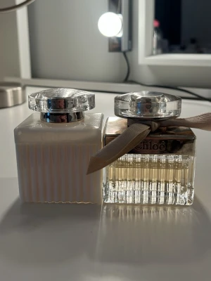 Två eleganta Chloé parfymer - Snygga och stilrena flaskor från Chloé, perfekta för dig som vill ha en modern och trendig parfym i din samling. En av flaskorna har en dekorativ rosett och båda har exklusiv design som passar på sminkbordet.