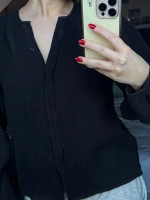 Svart Blus  - Jättesöt svart blus, så skön och passar perfekt både till att klä upp sig, men också för en chill kväll. Den är luftig och känns mjuk på kroppen. Långa ärmar som sitter loose.