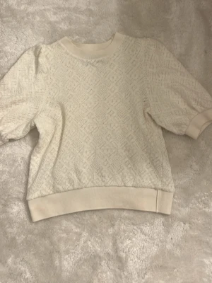 Vit mönstrad tröja Holly & Whyte S - Säljer en vit blus/tröja från Lindex. I princip nyskick då den bara är använd 2 gånger.