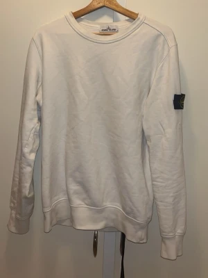 Vit sweatshirt från Stone Island!! - Väldigt fin, det är 2 små svarta prickar men går säkert bort med vanish!!! Annars lägger man inte märker på att de är där!!   Priset kan diskuteras. Hör av dej för mer information.
