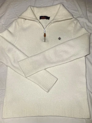 Morris half zip stickad - 100% merinoull. En stickad half zip tröja från Morris. Storlek S. Modellen är slim. Färgen är mellan vit och beige. Priset är inte hugget i sten.