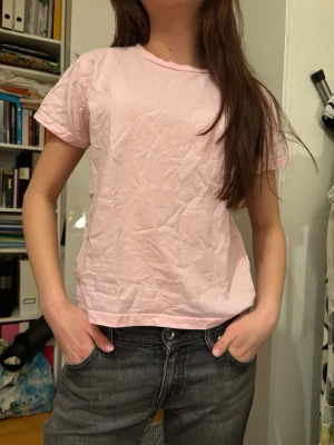 Ljusrosa basic t-shirt i bomull - Enkel och stilren ljusrosa t-shirt i mjuk bomull. Modellen är klassisk med rund halsringning och korta ärmar. Perfekt till jeans eller shorts för en chill look. T-shirten har en normal passform och är superbekväm att bära.