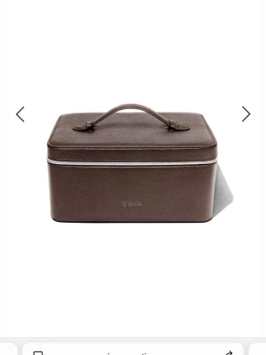 Brun necessär från CAIA i skinn - Säljer en stilren och rymlig brun necessär från CAIA med praktiskt handtag och dragkedja runt locket. Väskan är tillverkad i skinn och har en rektangulär form som gör den perfekt för att organisera smink eller småprylar. Enkel och snygg design med diskret logga framtill.