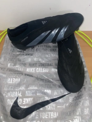 Adidas Predator svarta fotbollsskor - Säljer ett par svarta Adidas Predator fotbollsskor med silverdetaljer och låg profil. Skorna har en strömlinjeformad design utan snörning och mönstrad ovandel. Sulan har fasta dobbar för gräsplan. Perfekt för dig som vill ha grym touch och kontroll på planen. Använt i cirka 4-5 månader. Pris kan diskutera ganska lätt. 