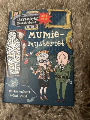 Mumiemysteriet - Följ med Lasse och Maja när de löser mysteriet på museet! En egyptisk mumie sägs ha vaknat till liv och en värdefull tavla har försvunnit. Spänning, humor och kluriga gåtor väntar i denna färgglada bok från LasseMajas Detektivbyrå.
