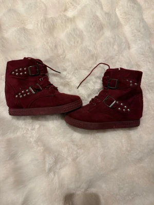 Mörkröda kilklackar - Snyggaste skorna i mörkröd! Kilklacken på insidan har blivit lagad en gång. Dragkedja på insidan av foten och snörning.