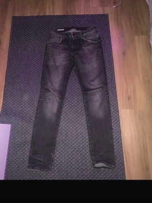 Svarta jack & Jones jeans storlek 30/32 - Säljer ett par svarta slim fit jeans från Jack&Jones med snygga slitningar och tvättad look. Modellen har fem fickor, knapp och dragkedja fram samt smal passform hela vägen ner. Perfekt för dig som gillar en tajt stil och vill ha jeans som sitter snyggt.