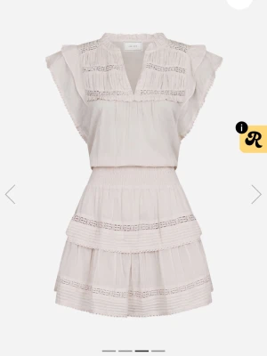 Ljusrosa volangklänning från Neo Noir  - Supersöt ljus kortklänning från Neo Noir med volanger och spetsdetaljer. Klänningen har v-ringad hals, ärmlös design med breda axelvolanger och ett lager-på-lager kjolparti. Tillverkad i mjuk bomull som ger en luftig och fräsch känsla. Mer livlig färg i verkligheten!!  Nypris - 900kr 