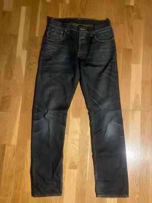 Nudie Jeans Big Bengt Night Thunder - Säljer ett par mörkblå jeans från Nudie Jeans, modell Big Bengt Night Thunder. Jeansen har klassisk femficksdesign, raka ben och snygga kontrastsömmar. Tillverkade i 100% bomull för skön känsla och slitstark kvalitet. Ifall mer frågor eller bilder är det bara att fråga!