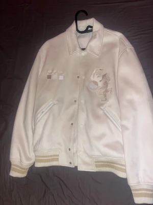 ZARA Vit bomberjacka  - vit bomberjacka från Zara med broderade detaljer. Perfekt för dig som gillar stilrena. Jag har använda den bara en gång! Mamma köpte den till mig.  tycker inte riktigt om det.