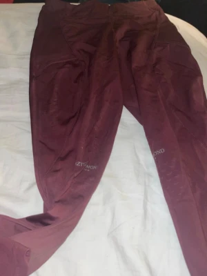 Aztec Diamond ridleggings  - Snygga vinröda ridleggings från Aztec Diamond med hög midja och smarta fickor på sidorna. Materialet är stretchigt och sitter tight, perfekt för ridning. Diskret logga på låret.  för små för mig det greppiga på insidan av benen är tyvärr inte greppigt längre men annars är dom jätte fina