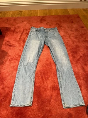  Jack and Jones jeans straight fit - Grå Jack and Jones jeans med rak passform och fem fickor. Jeansen har knappgylf och är tillverkade i slitstarkt bomullsmaterial. Perfekt för dig som gillar en tidlös och avslappnad stil. Jack and Jones patch baktill i midjan.