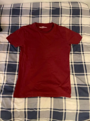 Vinröd t-shirt från Hampton Republic - Säljer en enkel och stilren vinröd t-shirt från Hampton Republic i storlek S. T-shirten har rund hals och korta ärmar, perfekt för dig som gillar klassiska plagg med snygg färg. Materialet är mjuk bomull som känns skönt mot huden.