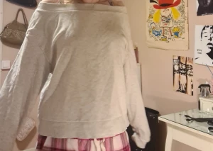 Ljusgrå offshoulder sweatshirt - Säljer en ljusgrå sweatshirt med offshoulder-design och långa ärmar. Tröjan har en loose passform och bred mudd nertill. Perfekt för en chill och avslappnad stil.