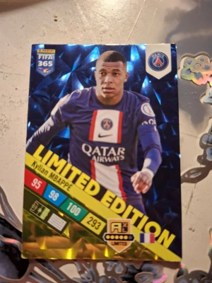 Mbappe fotbollskort Limited Edition - Mbappe fotbollskort i PSG med röd och vit rand mitt på bröstet och klubbens logga. Västen har sportig design och är perfekt för dig som gillar fotboll och vill sticka ut med en limited edition-look.
