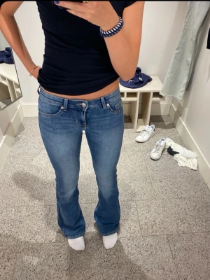 Blå bootcut jeans låg midja - Säljer ett par snygga blå jeans med bootcut-snitt och låg midja från H&M. Midjemått, 35cm, innebenslängd 78cm