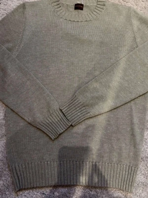 Rose and born Kashmir/silk rundhalsad - Superskön grå tröja från Rose & Born i lyxig mix av silke, kashmir och lin. Klassisk rund halsringning och ribbade muddar vid ärmslut och nederkant. Färgen är ljusgrön. Perfekt för dig som gillar stilrena och mjuka plagg.