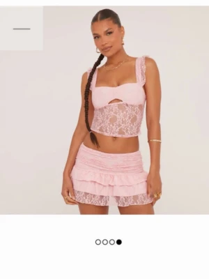 Rosa spetsig croppad topp från EGO - Säljer en ljusrosa croppad topp från EGO med breda axelband och volangdetaljer. Toppen är i genombruten spets med blommigt mönster och har en liten cut-out framtill. Perfekt för dig som vill sticka ut med en söt och trendig look. Super fin, säljs pga tog fel storlek Storlek 36 på båda   