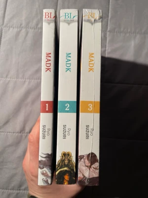 MADK (volym 1-3) - MADK är en mörk och spännande manga i tre volymer med unika illustrationer och explicit innehåll. Perfekt för dig som gillar BL och vill ha något annorlunda och intensivt i bokhyllan. Serien är på engelska och passar unga vuxna som söker något utöver det vanliga. Bok 1 och 3 är nya och inplastades, bok 2 är i bra begagnat skick.