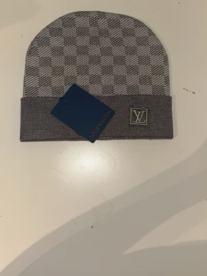 Grå rutig mössa  - Väldigt fin mössa och väldigt bra kvalite. Den funkar till alla åldrar 