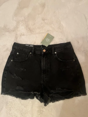 Svarta high waist jeansshorts  - Snygga svarta högmidjade jeansshorts slitna detaljer. Helt oanvända med prislapp. Skriv ifall ni har några frågor 😻