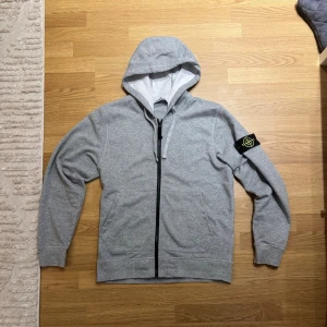 Stone Island Zip-Hoodie - En grå Stone Island Zip Hoodie i storlek Medium. Endast använd en gång, alltså i princip nyskick.