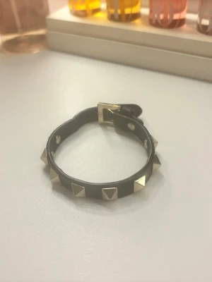 Svart Valentino armband  - Säljer mitt valentino armband som köptes i deras egna affär runt 2023 sen den inte kom till användning 💘Den har inga tecken på användning och kan säga att den ser som ny ut, bara om man kollar super noga kan man se lite damm aktiga fläckar men inget som märks alls. Har ingen box kvar eller någonting men på andra bilden kan man se valentino loggan som inte finns på fejk Valentino armband.💞