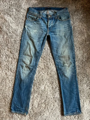 Nudie Jeans 31/32 - Ett par schyssta Nudie Jeans med snygg tvätt och slitningar. Fint skick!