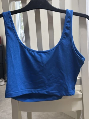 Blå croppad linne - Snygg blå croppad linne med breda axelband och rundad urringning. Använd 1 gång 