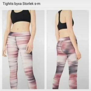 Två par träningstights S-M - Säljer två par snygga träningstights i storlek S-M. Ena paret är mörkgrå med ljusrosa midja och vita linjer längs benen, det andra paret har ett coolt mönster i rosa, grått och svart. Båda är höga i midjan och sitter tight för en sportig look. Säljes 2 par 