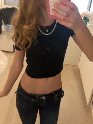 Svart croppad topp - Säljer en svart croppad topp med korta ärmar. Toppen har en tight passform och är perfekt att matcha med höga jeans eller kjol. Enkel och stilren design utan synliga mönster eller detaljer.