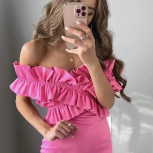 Rosa offshoulder volangklänning Zara - Superfin rosa kortklänning från Zara med offshoulder-modell och stora volanger över byst och axlar. Klänningen är aldrig använd och säljs ej längre pgv limited edition. INGA DEFEKTER!         STRL M men liten i storlek så passar S-M.  