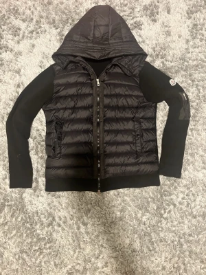 Svart Moncler pufferjacka med huva - L/XL.