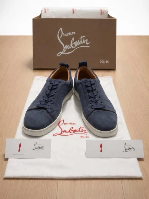 Blå loubs utan spikar - Snygga blå sneakers från Christian Louboutin med ovandel i mocka och klassisk vit sula. Skorna har rund tå, snörning och diskreta detaljer som ger en lyxig känsla. Perfekta för dig som vill sticka ut med stil.