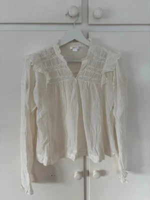 Söt vit blus - Söt vit blus med romantiska spetsdetaljer och volanger vid axlarna från Gina Young i storlek 170🩷