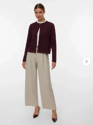 Oanvänd Brun kofta från Vero Moda, M - Mörkbrun kofta från Vero Moda i storlek M. Enkel design med rund halsringning och en stor knapp framtill. Tillverkad i mjukt material som passar perfekt till lager på lager under höst och vinter.