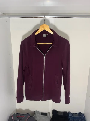 Vinröd kofta från ASOS - Stilren vinröd kofta från Asos med dragkedja framtill och klassisk krage. Koftan har två fickor på sidorna och är tillverkad i ett mjukt bomullsmaterial. Strl S, den passar nog dig som är lite smalare som ni ser på mina bilder är jag lite större byggd.